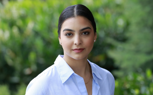 Un portrait de Kaajal qui regarde l’appareil photo, habillée d’une chemise bleue à boutons. 
